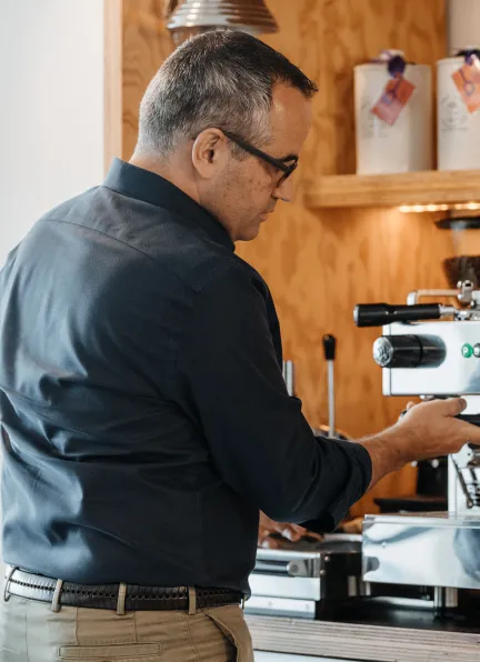 Person an Kaffeemaschine